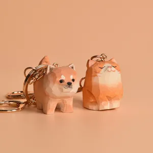 Wooden Shiba Inu and cat keychain close-up, hand-carved animal key ring pair detail shot.