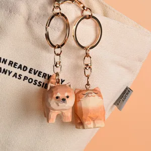 Close-up of cute wooden Shiba Inu and cat keychains pendant detail showing fine texture.