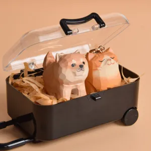 Detailed shot of cute wooden Shiba Inu and cat keychains inside a mini suitcase display box.