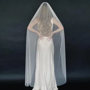 Detailed view of long white bridal veil with hair comb for wedding photoshoot and ceremony.