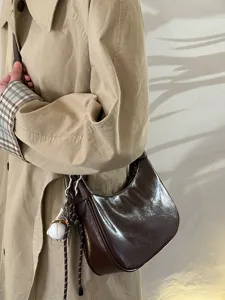 Detailansicht der braunen Damen Lackleder Hobo Schultertasche für den täglichen Weg zur Arbeit.