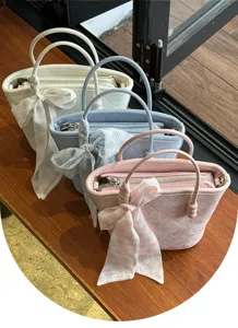 Vue détaillée de superbes sacs cabas matelassés blancs, bleus et roses avec joli nœud.