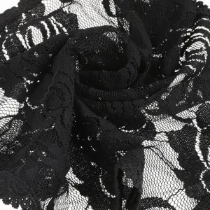 Detailed close-up of black lace fabric featuring intricate floral patterns and mesh texture.