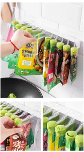 Close-up detail of wall-mounted kitchen seasoning pouch storage rack with sealing clips.