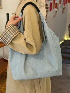 Casual denim tote bag detail shot, large capacity single shoulder daily commuter bag.
