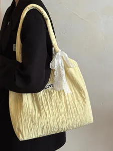 Detailansicht einer gelben Canvas-Tragetasche mit weißer Schleife und Label für das Pendeln.