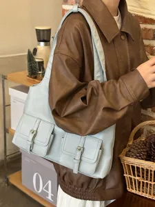 Detailed view of light blue leather shoulder bag with multi-pockets and metal buckle.