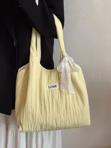 Detailansicht einer lässigen gelben Canvas-Tragetasche mit weißer Schleife und Label.