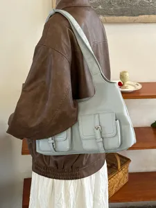 Multi-pocket light blue shoulder bag detail showing stylish buckle and soft leather texture.