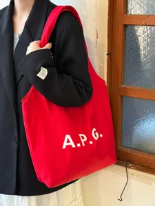 Κόκκινη τσάντα ώμου από καμβά με κομψή εκτύπωση γραμμάτων, ιδανική για μετακινήσεις.