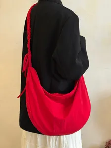 Detailed view of a red slouchy cloud hobo bag worn on shoulder, stylish daily commute choice.