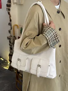 Detailed shot of white multi-pocket shoulder bag, casual PU leather tote underarm bag.