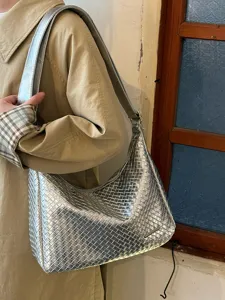 Detail der metallisch silbernen gewebten Umhängetasche, sehr stilvolles Hobo-Design.