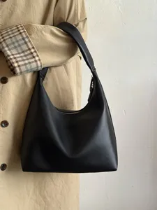 Detail view of black soft leather underarm bag, minimalist daily casual shoulder bag style.