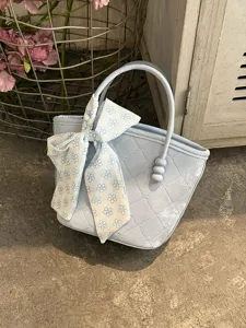 Gros plan détail du sac à main chic bleu clair avec ruban nœud et poignée perle.