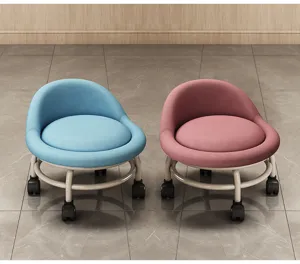 Detailansicht des niedrigen Rollhockers mit weichem Kissen und Lenkrollen in Blau und Rosa.
