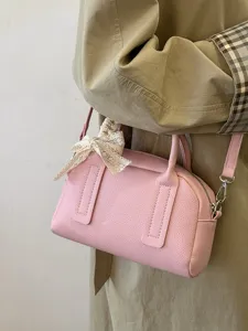 Close-up detail of a pink leather Boston shoulder bag with a charming lace bow decoration.