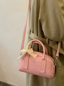 Pink Boston shoulder bag detail showing stylish design, handle lace bow, and premium texture.