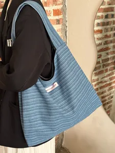 Detailed view of the stylish blue striped canvas shoulder tote bag, perfect for daily commute.