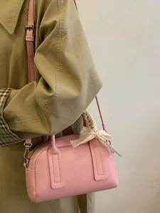 Chic pink Boston shoulder bag detail with elegant lace bow accessory and sleek hardware.