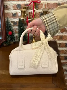 Korean style chic Boston pillow bag detail shot, elegant cream white handbag with lace bow.