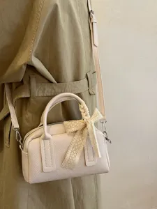 Detail of Korean style niche Boston pillow handbag with cute lace bow detail for daily commute.