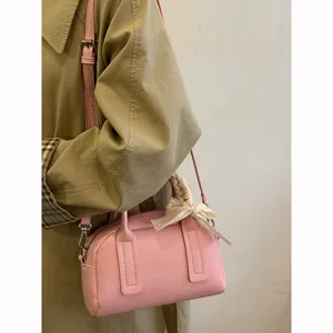Chic pink Boston pillow bag with lace bow, stylish shoulder handbag for women daily commuting.