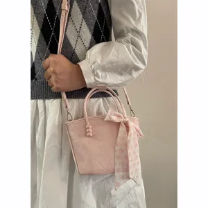 Sac à main matelassé rose doux avec ruban floral, sac bandoulière élégant et chic.