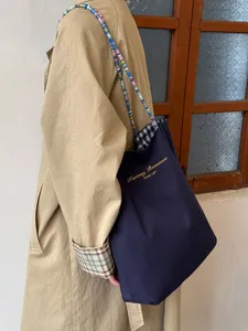 Detailansicht einer koreanischen Canvas-Tasche mit bunten Perlen und Karo-Muster.