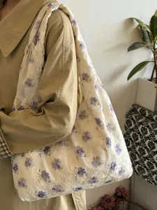 Primer plano del bolso tote de lona con flores retro japonesas y detalles bordados.