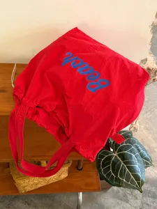 Detailansicht einer roten koreanischen Canvas-Tasche mit blauem Beach-Druck für den Alltag.