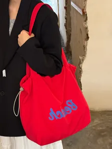 Koreanische rote Canvas Shopper Tasche mit blauem Buchstaben Print als grosse Schultertasche.