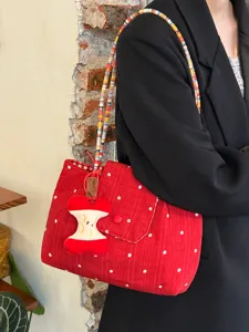 Detailed shot of Korean red floral canvas shoulder bag with colorful beaded strap and cute charm.