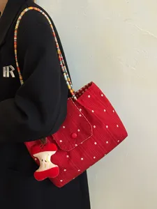 Korean style red plaid canvas shoulder bag for women with colorful woven straps and cute pendant.