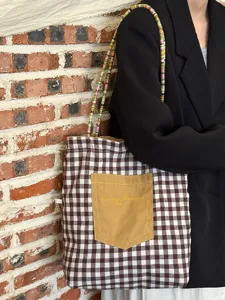 Detailansicht der koreanischen Karomustertasche mit bunten Perlen-Schulterriemen und Tasche.
