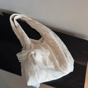 Elegant beige lace shoulder tote bag with bow, casual underarm handbag for women commuting.