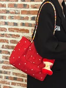 Korean style red canvas shoulder bag with colorful braided strap and cute apple pendant for women.