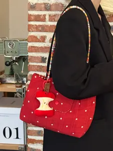 Red plaid canvas shoulder bag with colorful beaded strap and apple pendant, stylish commuter use