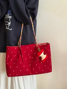 Red floral canvas tote bag with beaded straps and cute apple pendant for women daily commuting.