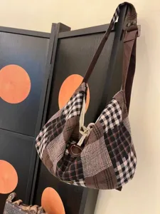 Detailed view of retro patchwork plaid canvas shoulder bag showing textured fabric and straps.