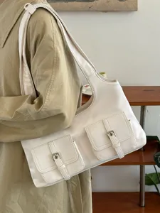 Detail shot of a chic white shoulder bag featuring multi pockets, metal buckles, and soft faux leather.