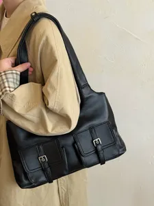 Close-up detail view of a black multi-pocket shoulder bag, showing front buckle design.
