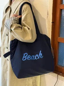 Detailansicht einer koreanischen dunkelblauen Segeltuchtasche mit Strand-Aufdruck.