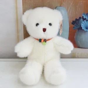 Detailed close-up of white plush teddy bear with cute necklace and star pendant.