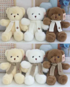 Cute plush teddy bear doll with knitted scarf and brooch, soft stuffed animal gift for kids.