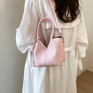 Pink woven leather bucket bag with top handle and shoulder strap for women daily commute.