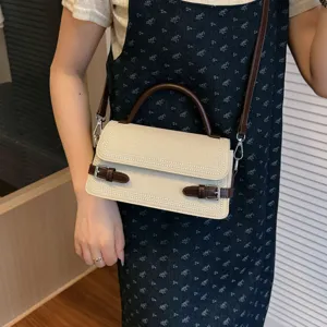 Stylish vintage commuter crossbody bag with top handle and chic buckle details for daily use.