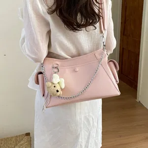 Stylish pink leather shoulder bag with chain strap and cute bear pendant for daily wear.