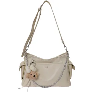 Beige leather shoulder bag for women, chic crossbody tote with metal chain and cute bear pendant.