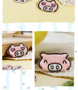 Detailed close-up shot of cute pink cartoon pig embroidery patch for DIY clothing decoration.